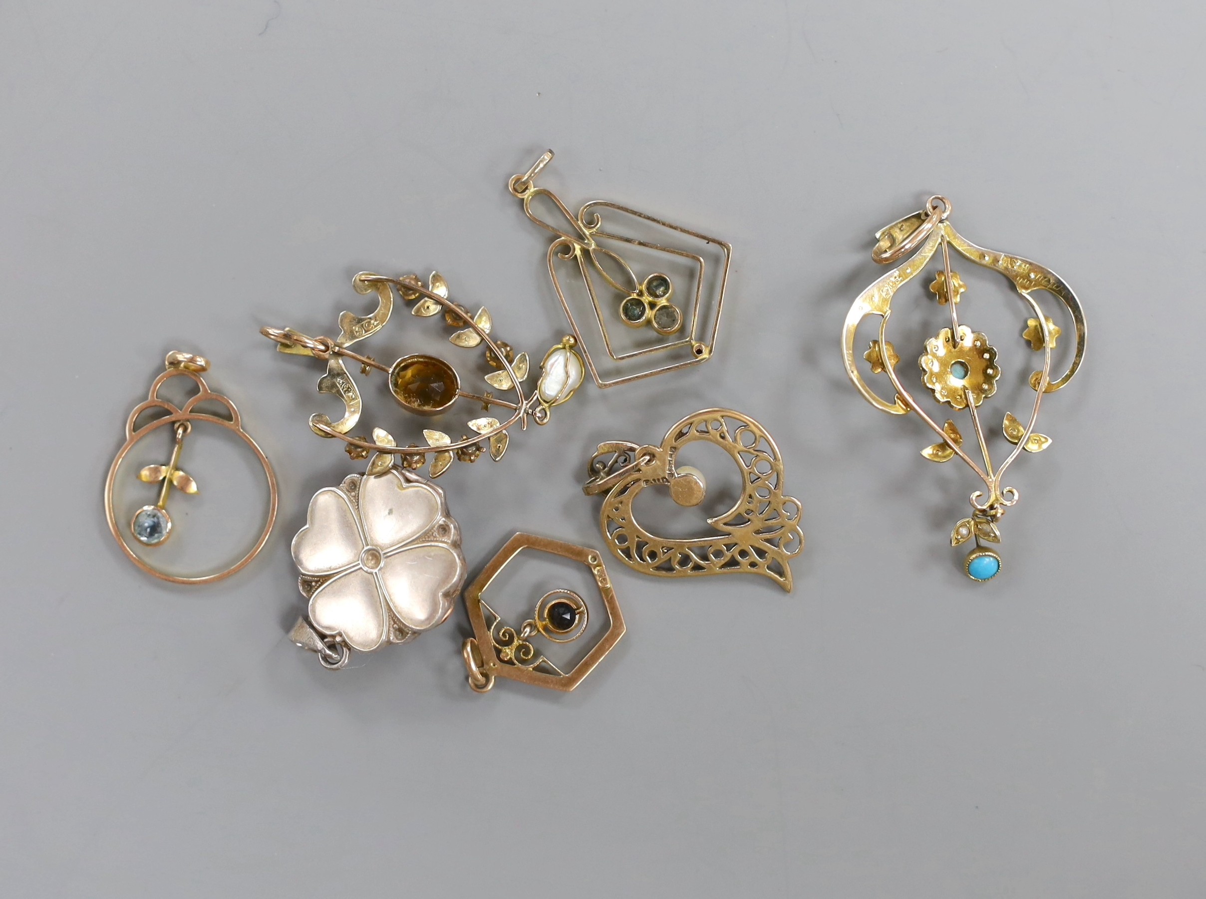 Seven assorted mainly early 20th century pendants, including 9ct, seed pearl and turquoise, white metal, marcasite and mother of pearl and a 9ct citrine and seed pearl.
